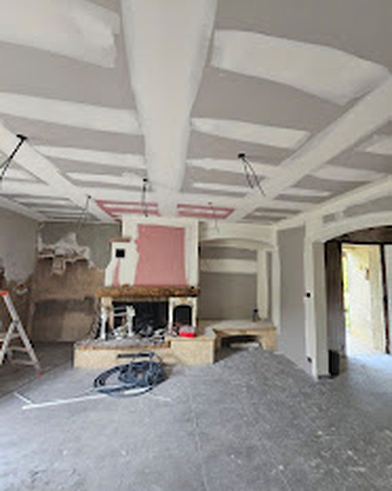 Séjour en cours de plâtrerie, cloisons montées et plafond en préparation.