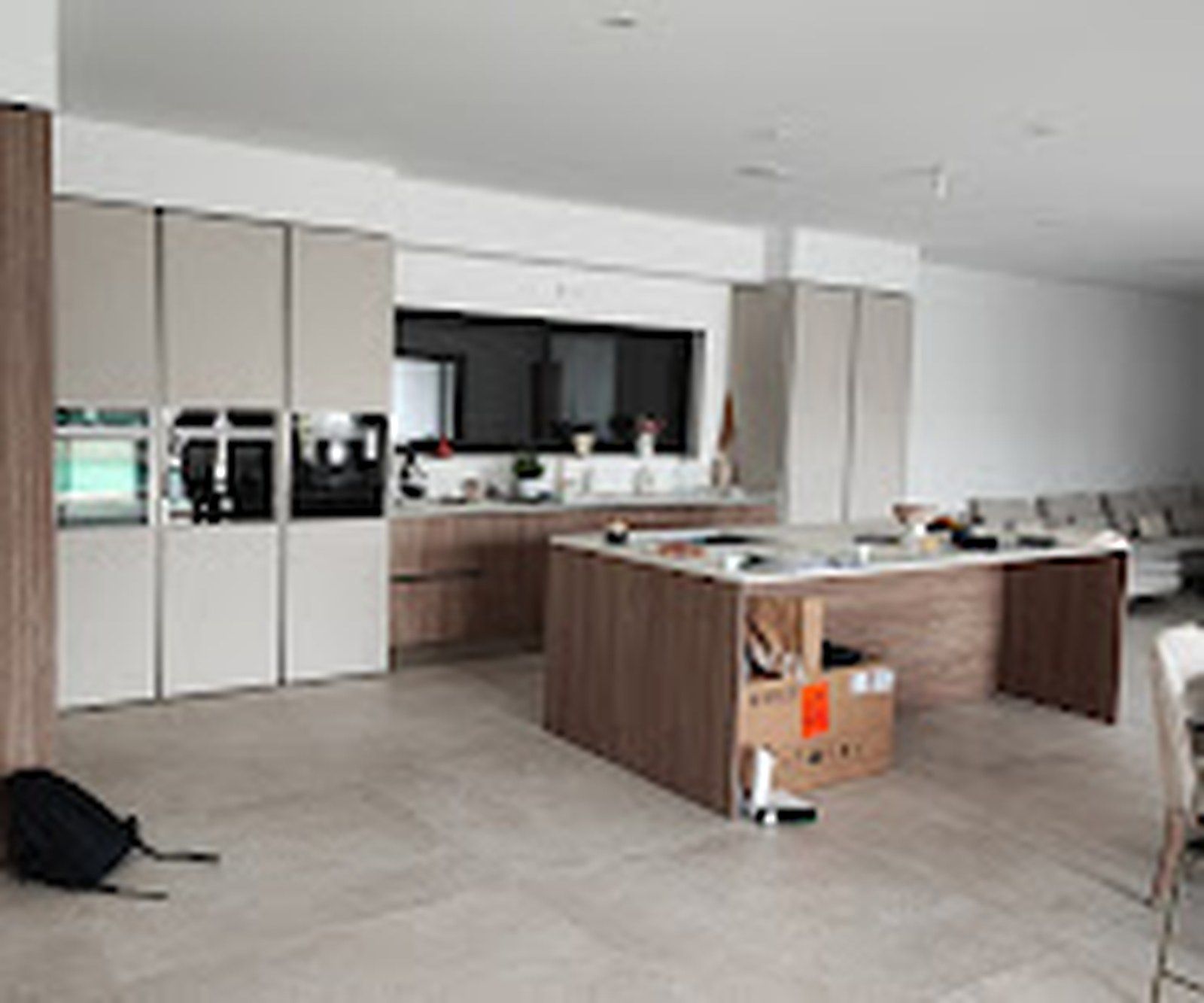 Cuisine équipée en fin de chantier, avec îlot central et sol carrelé.